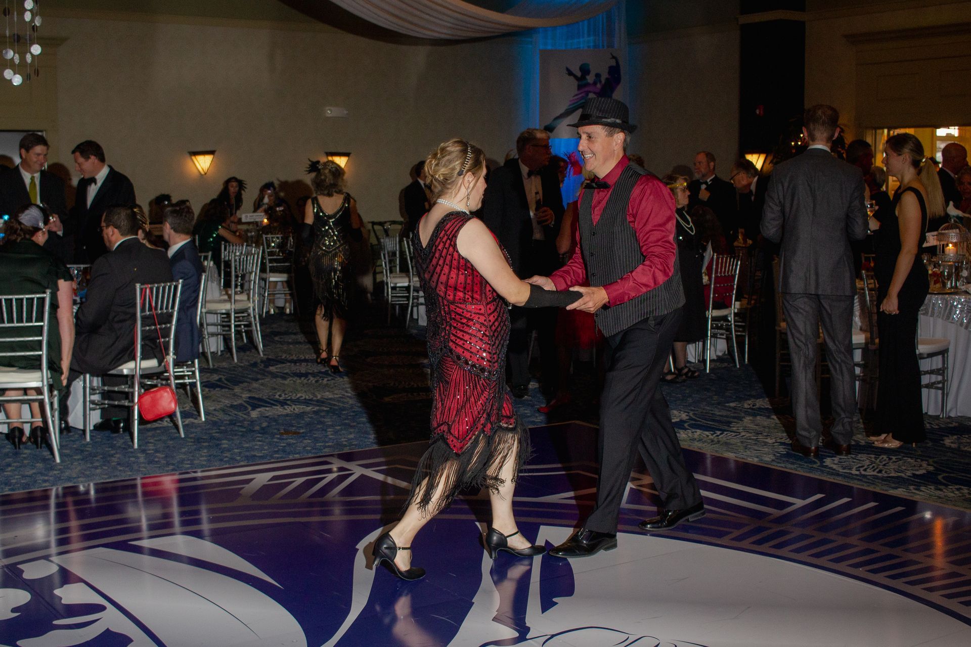 A man and a woman are dancing on a dance floor