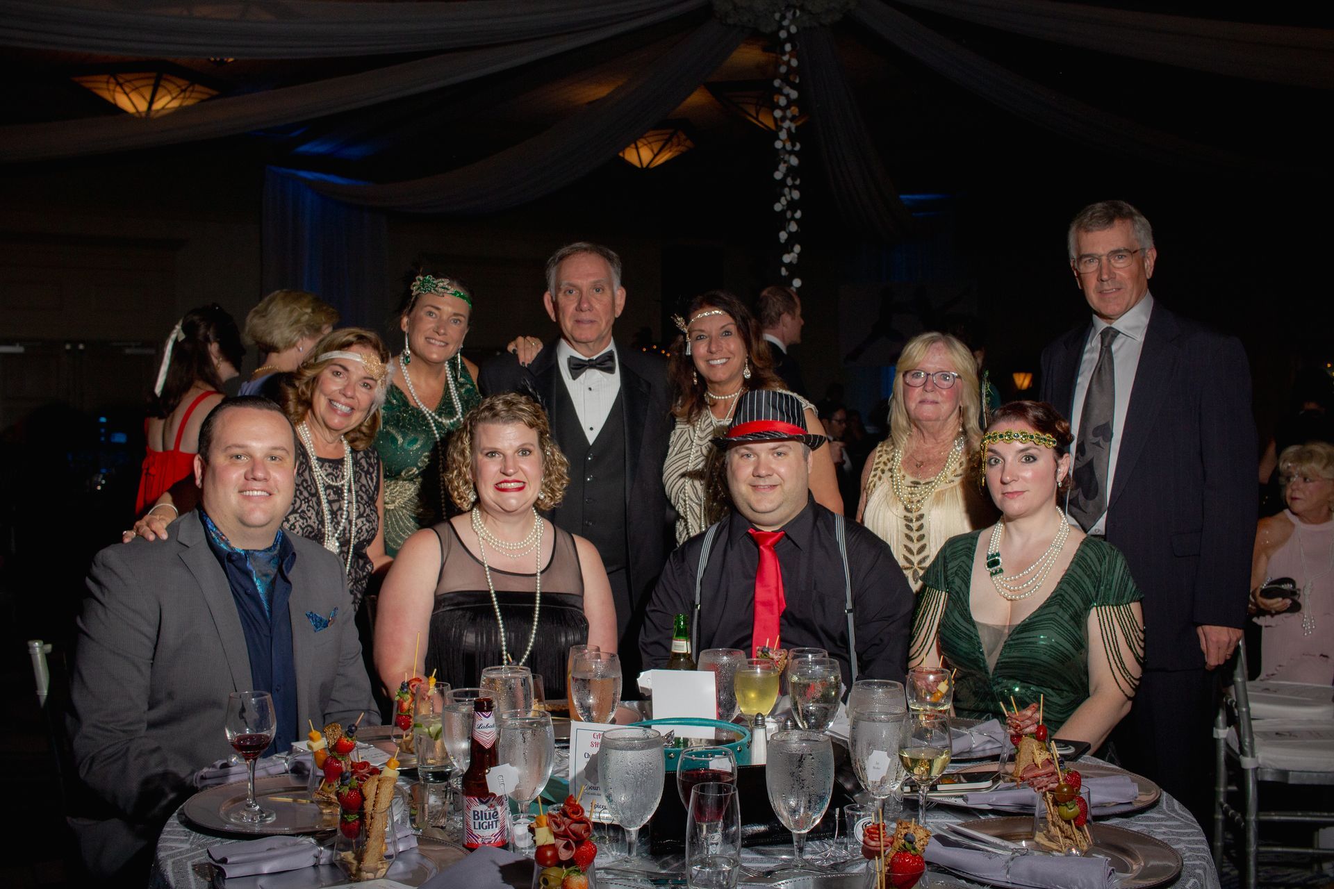 A group of people are posing for a picture at a table at a party.