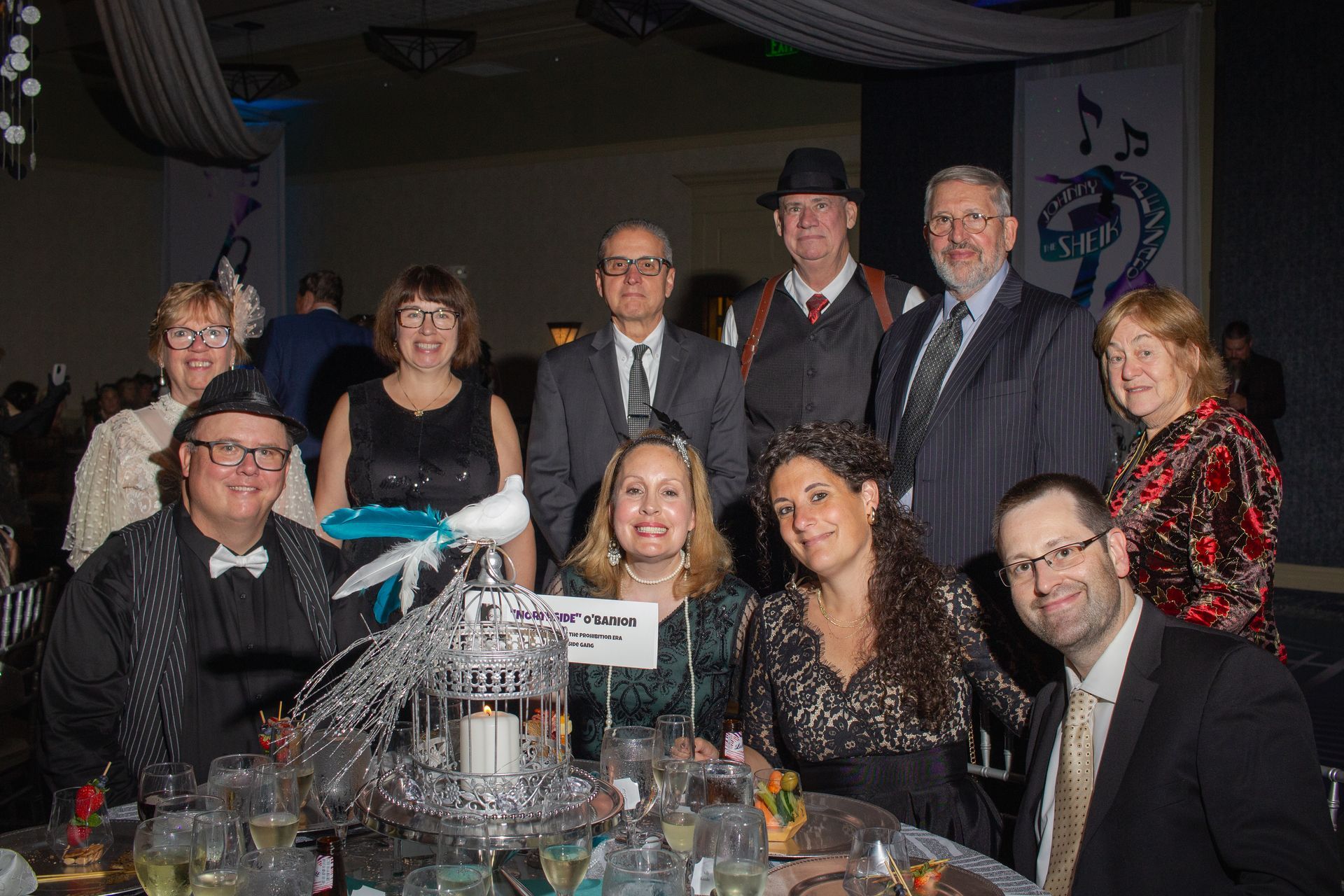 A group of people are posing for a picture at a table at a party.