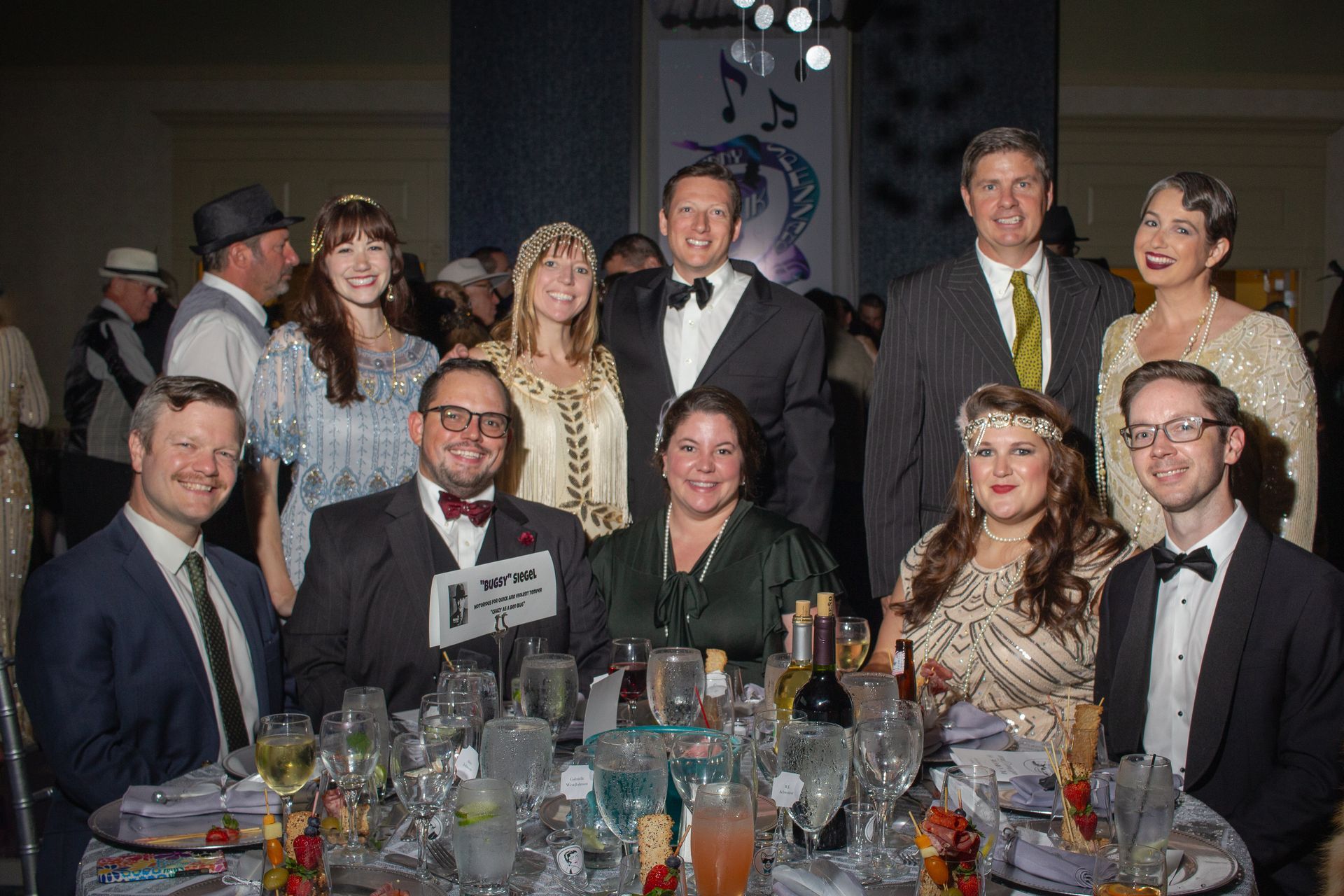 A group of people are sitting at a table at a party.