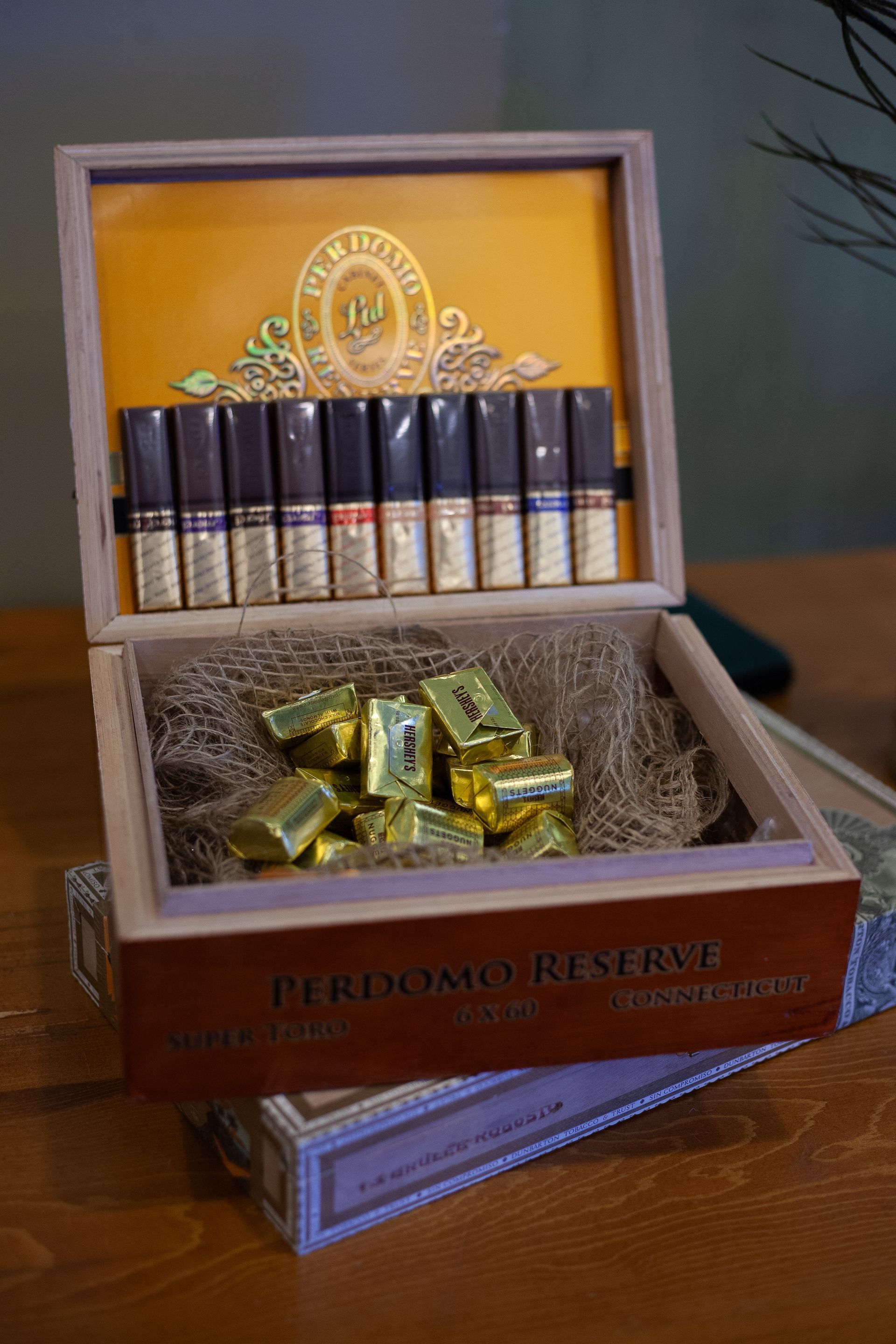 A box of cigars is sitting on top of a wooden table.
