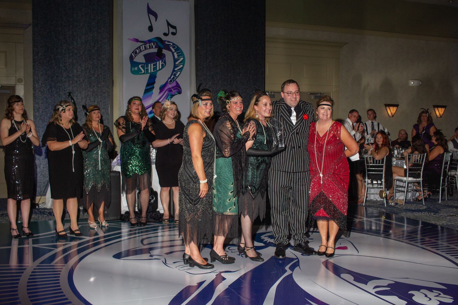 A group of people are posing for a picture on a dance floor