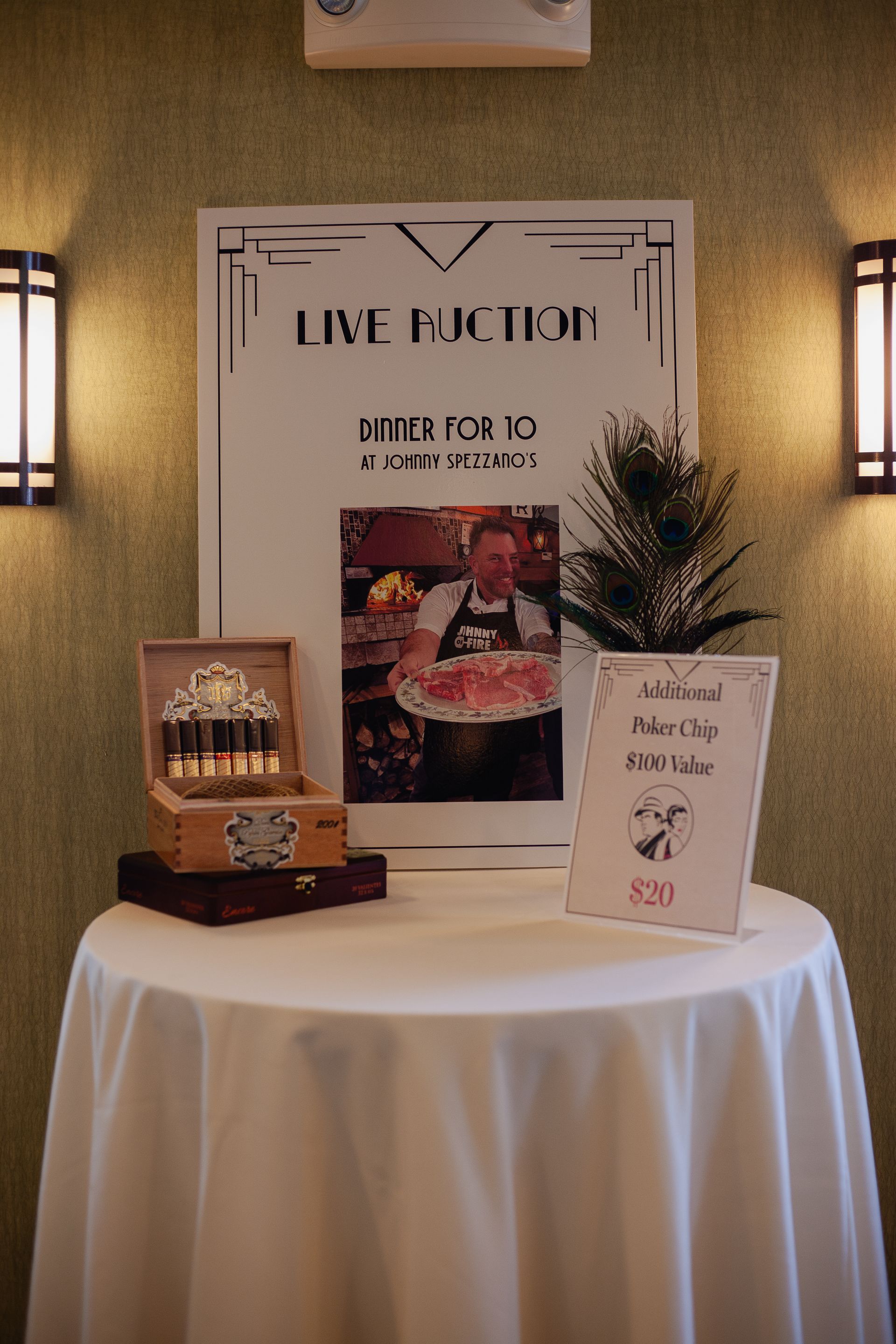 A table with a white table cloth and a sign on it.