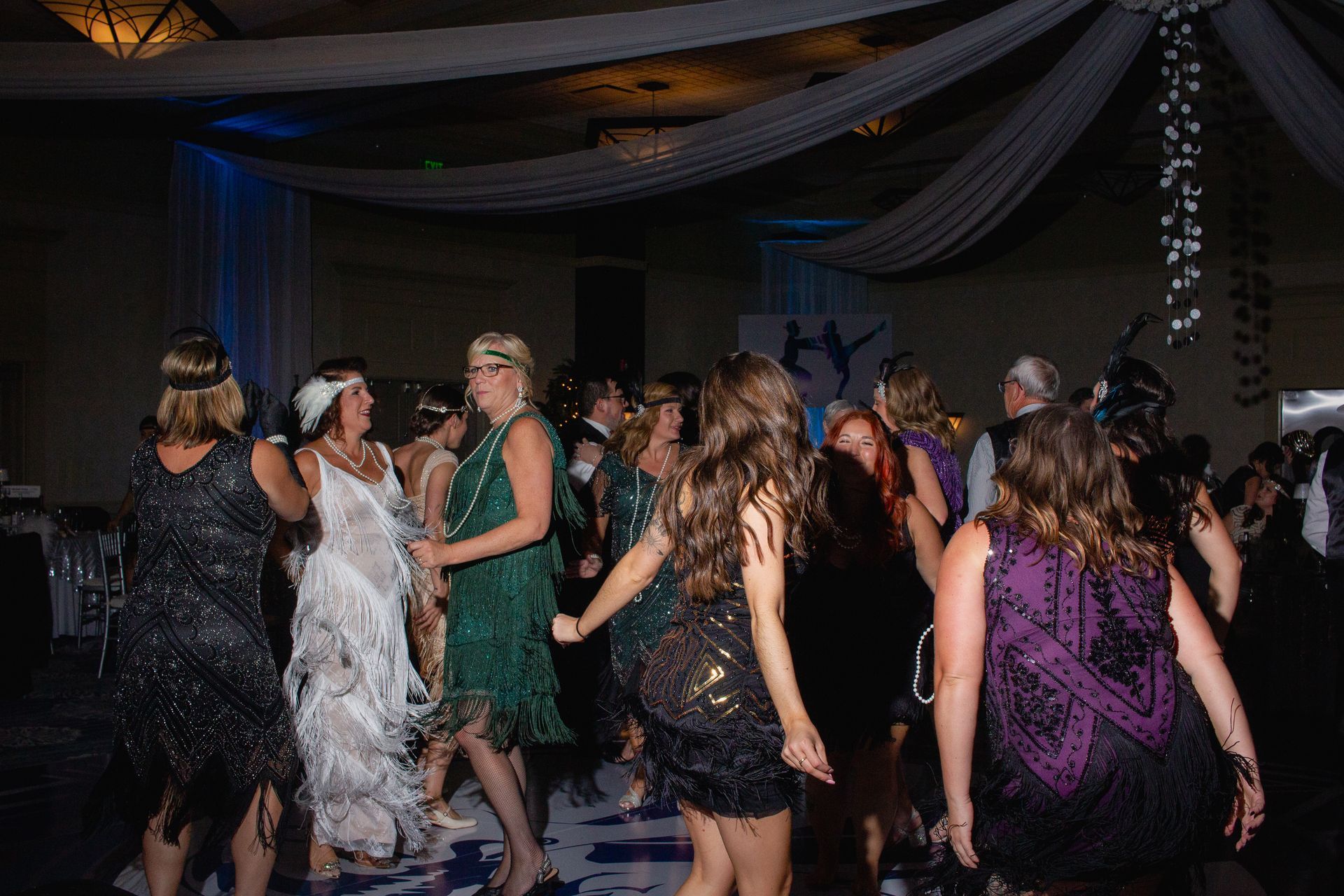 A group of women are dancing on a dance floor at a party.