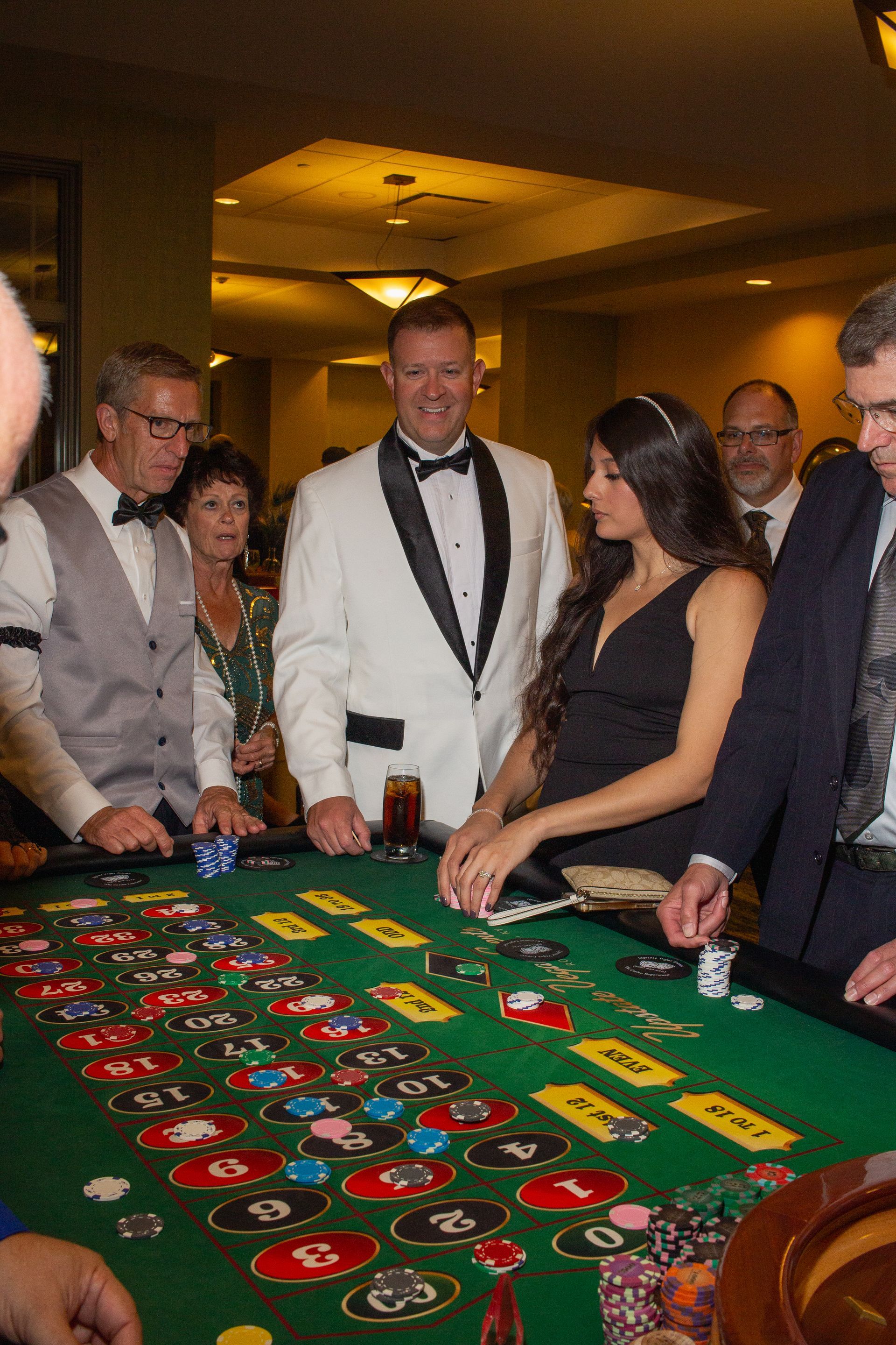 A group of people are playing roulette in a casino.