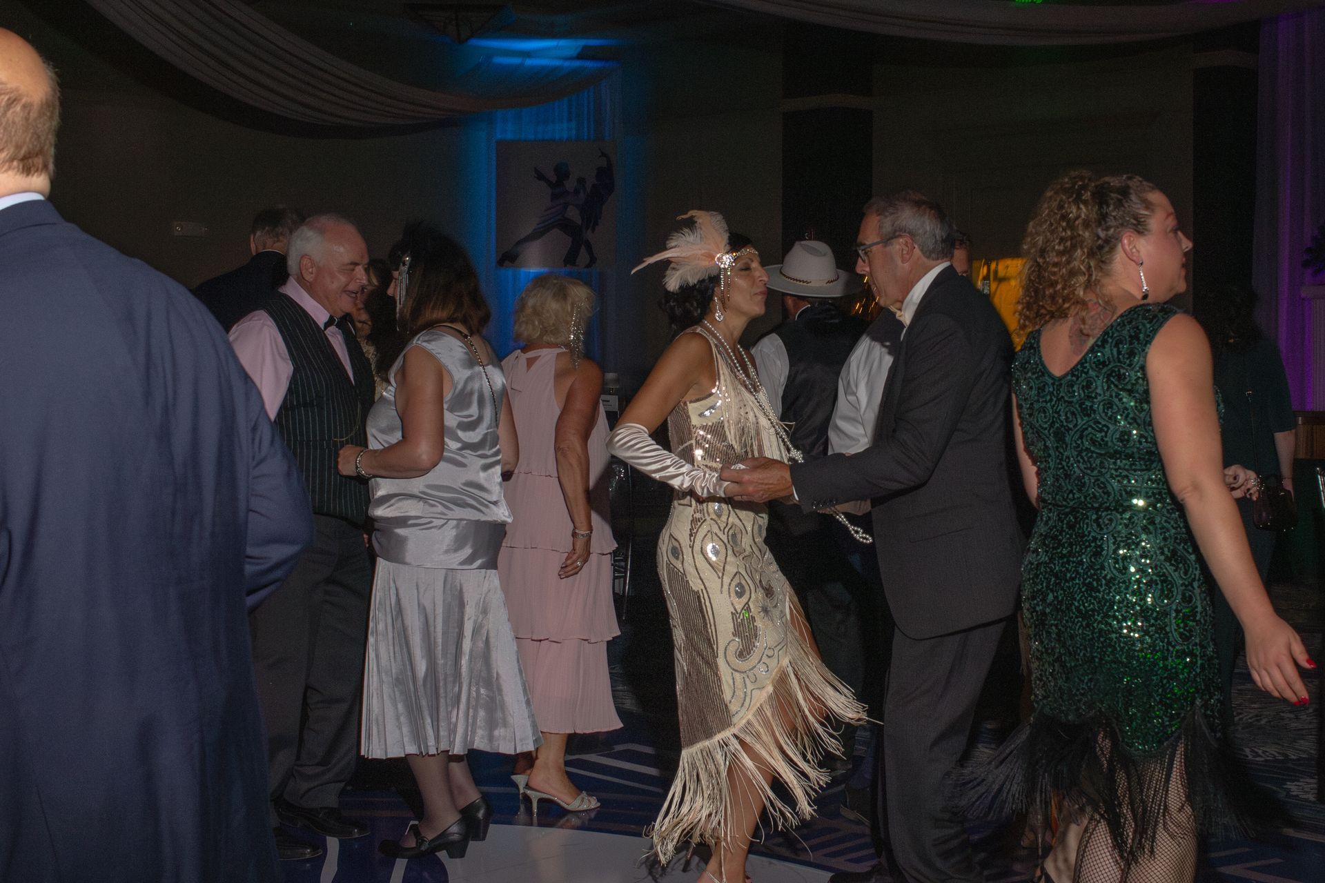 A group of people are dancing in a dark room.