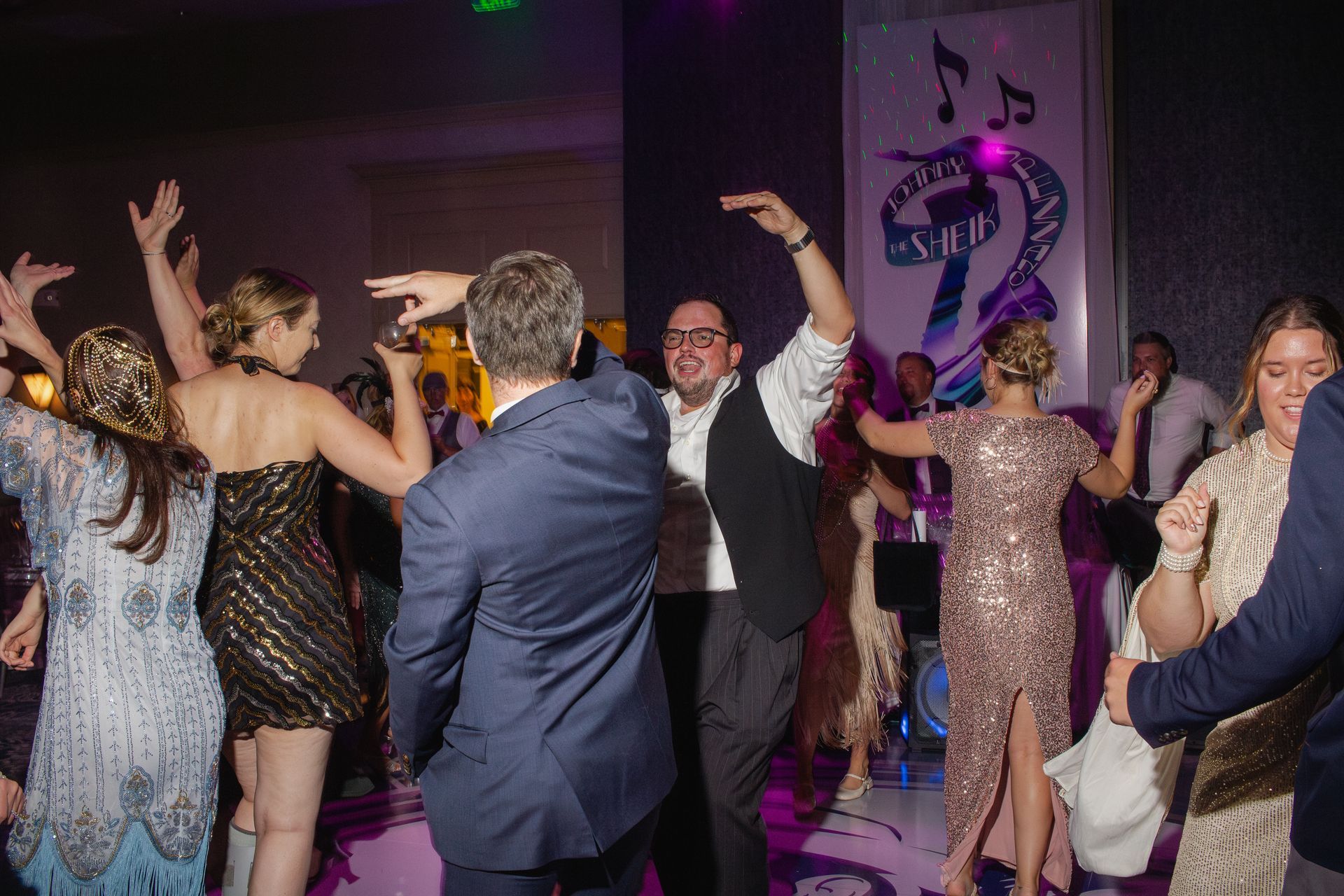 A group of people are dancing on a dance floor at a party.