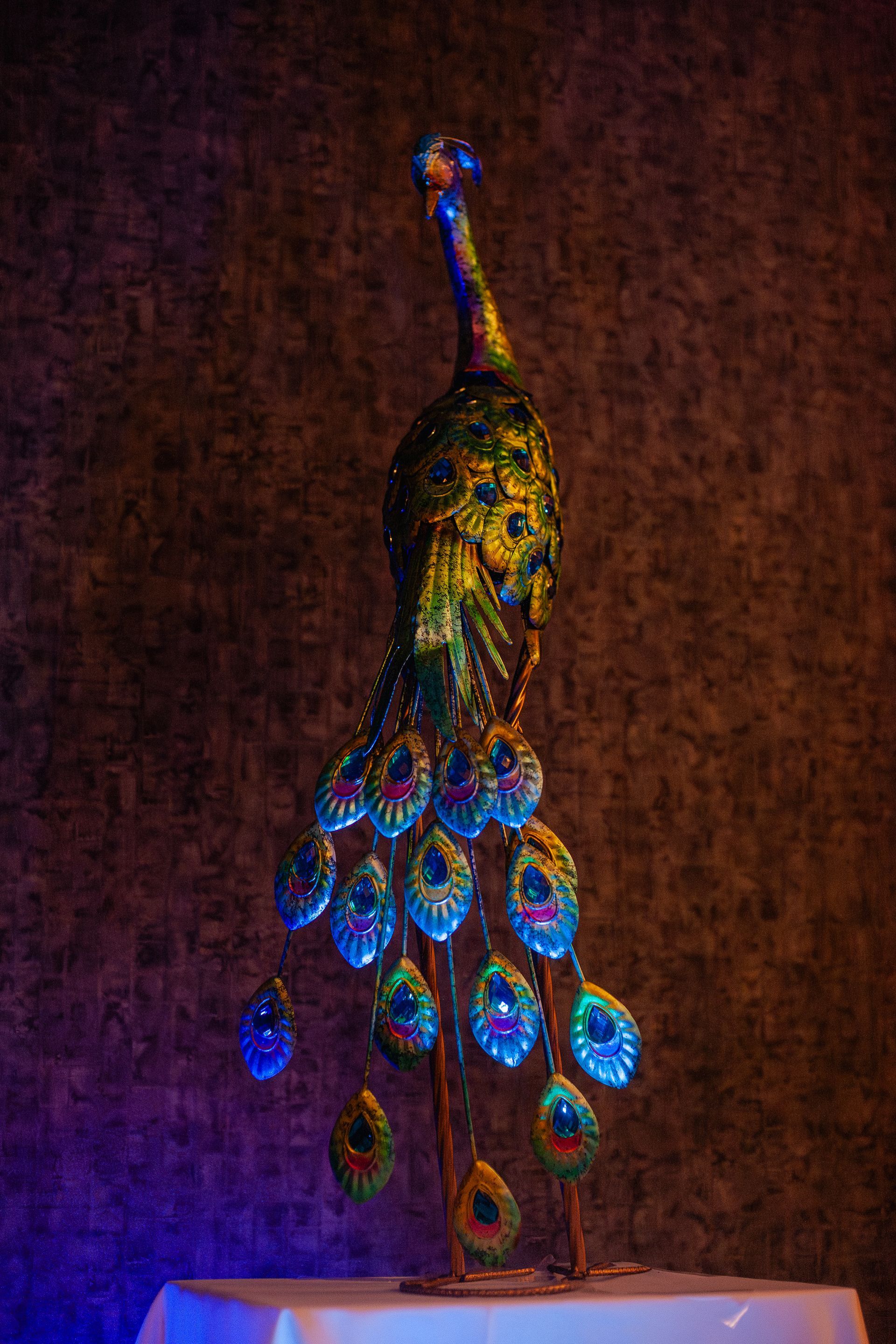 A peacock statue is sitting on top of a table.
