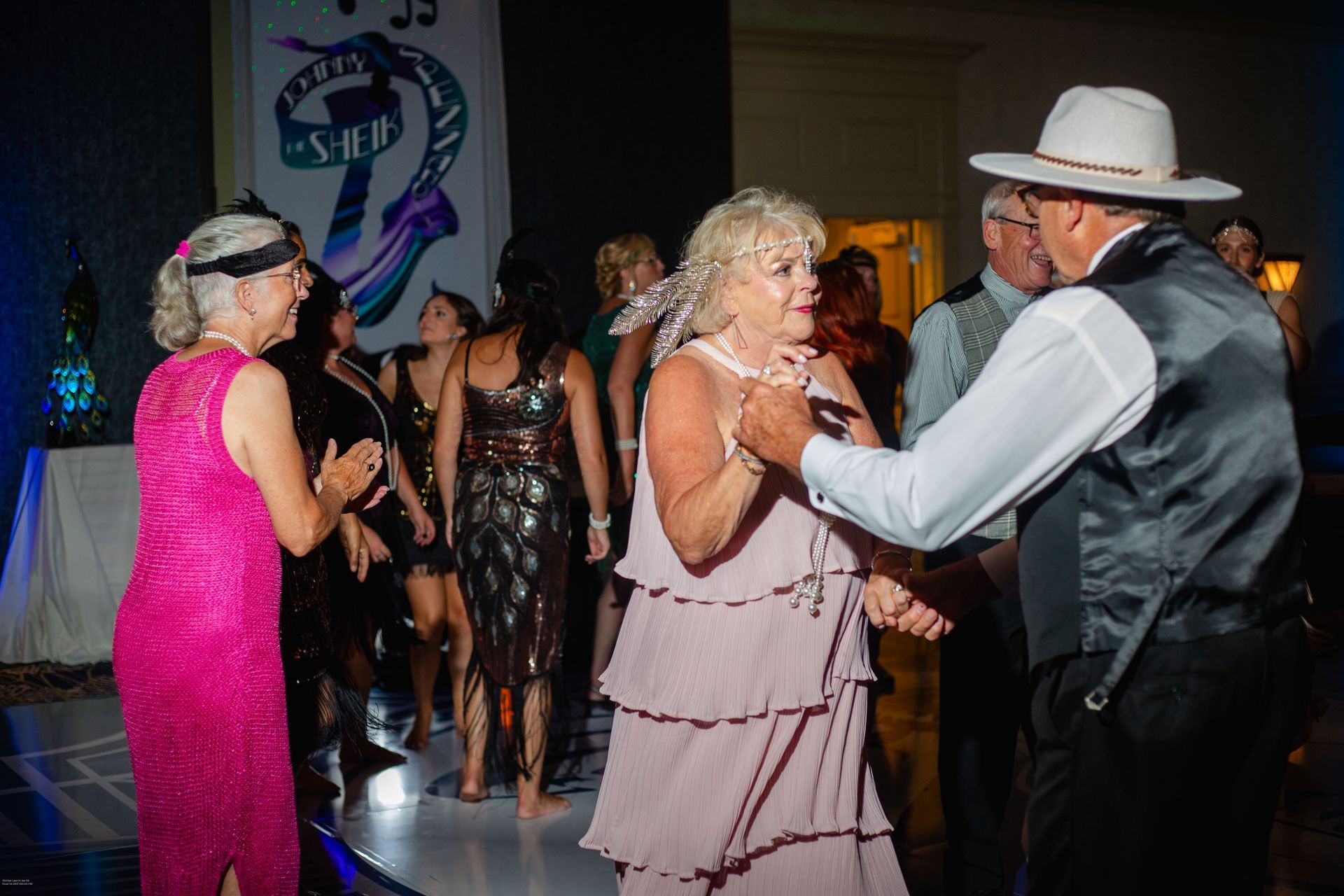 A group of people are dancing on a dance floor at a party.