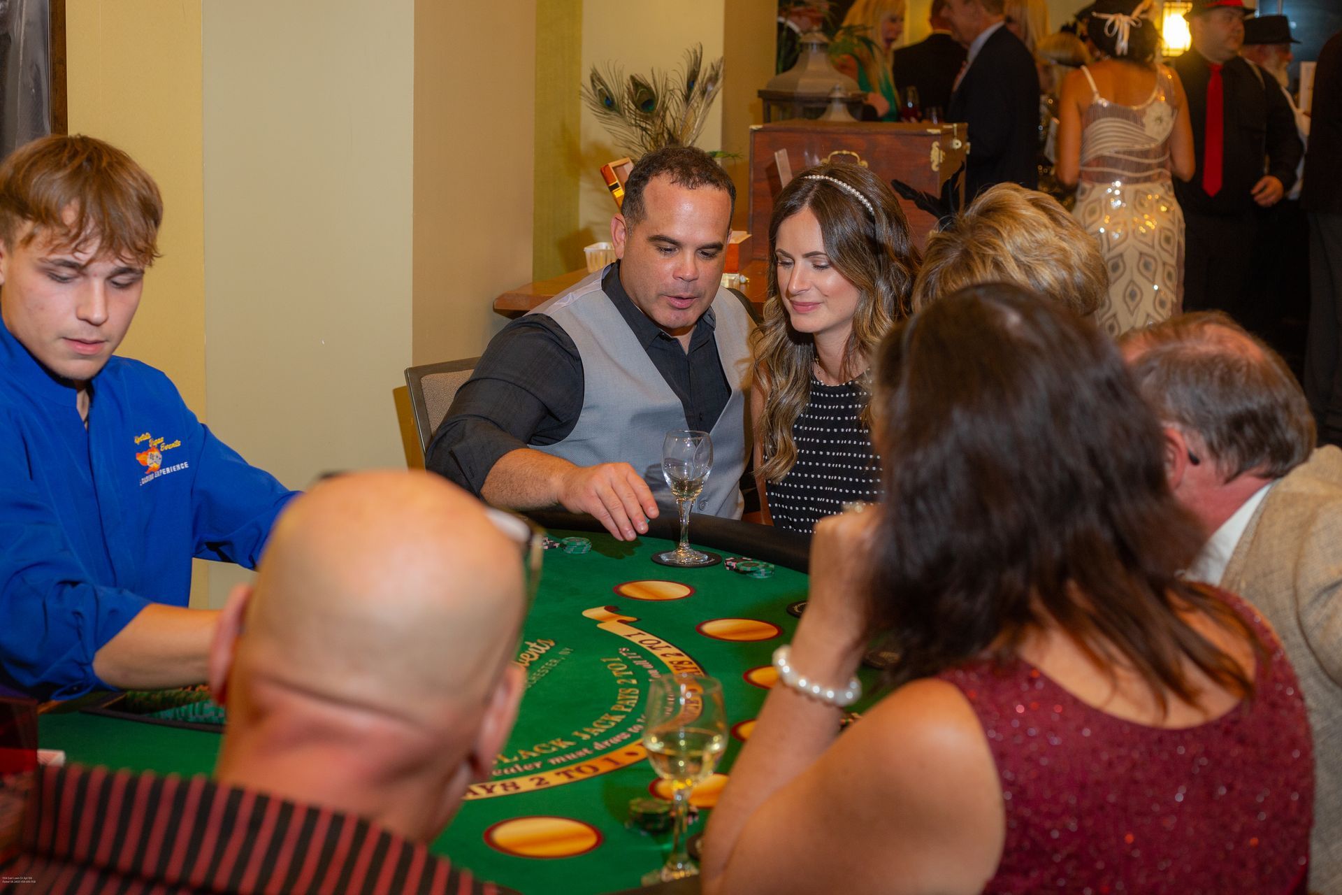 A group of people are sitting around a table playing a game of blackjack.