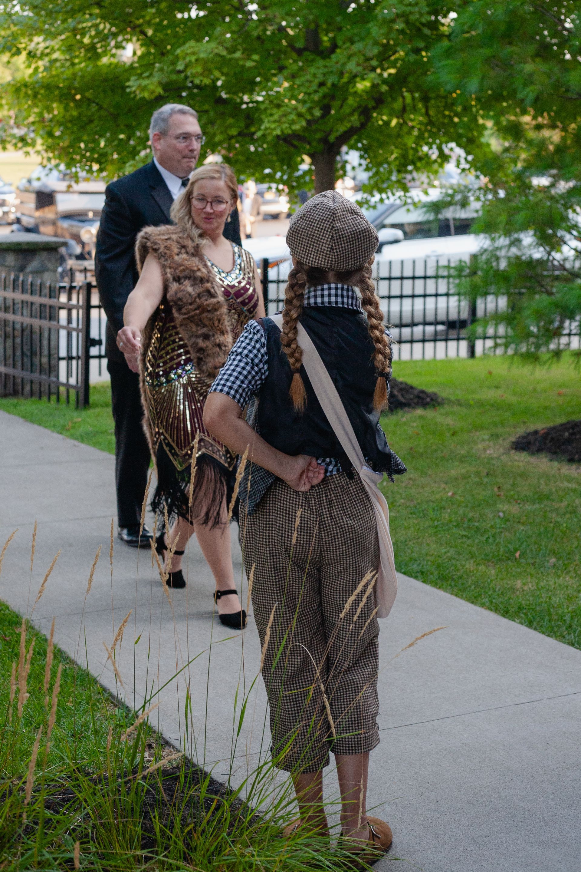 A group of people are walking down a sidewalk.