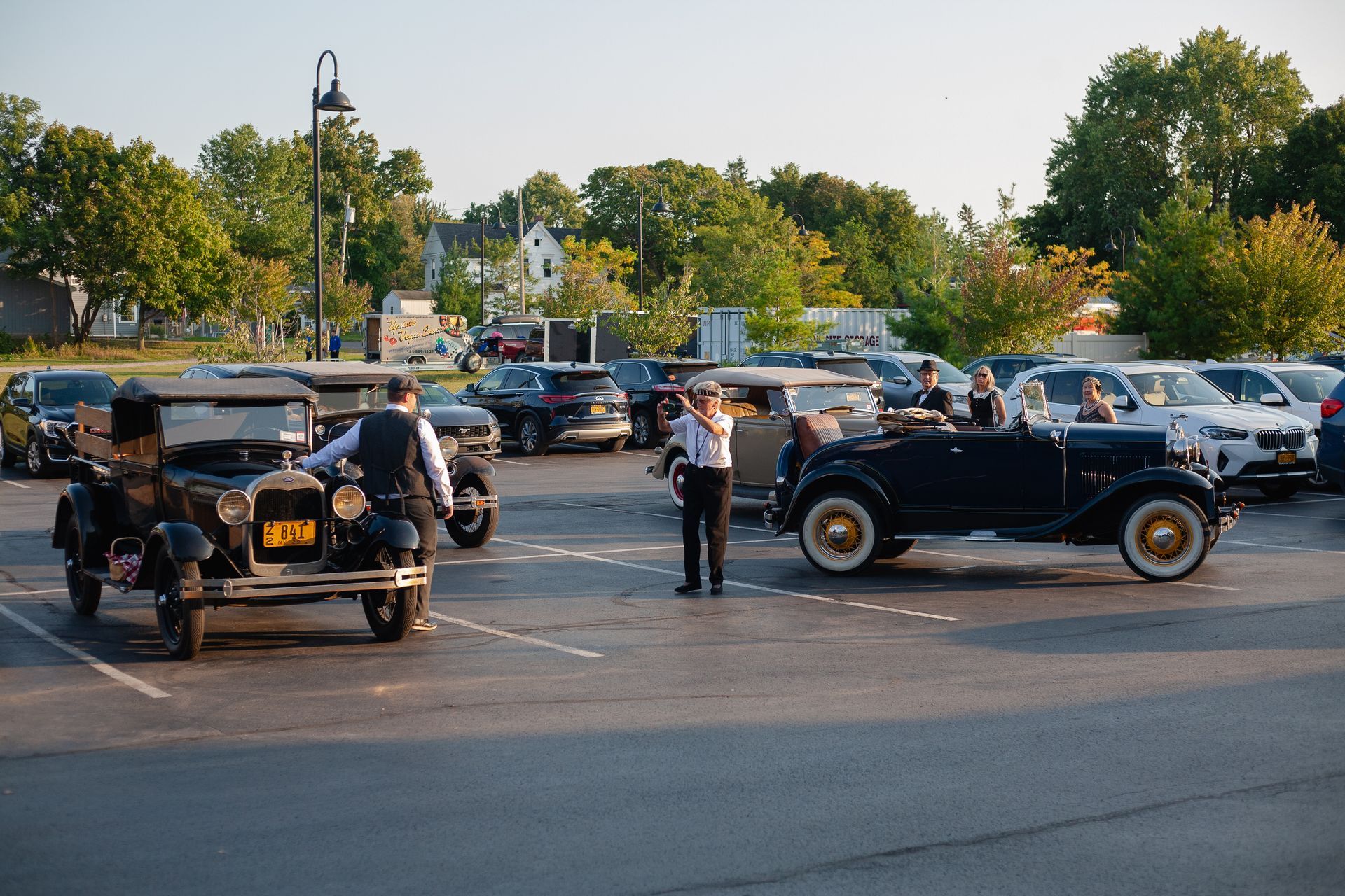 A group of old cars are parked in a parking lot