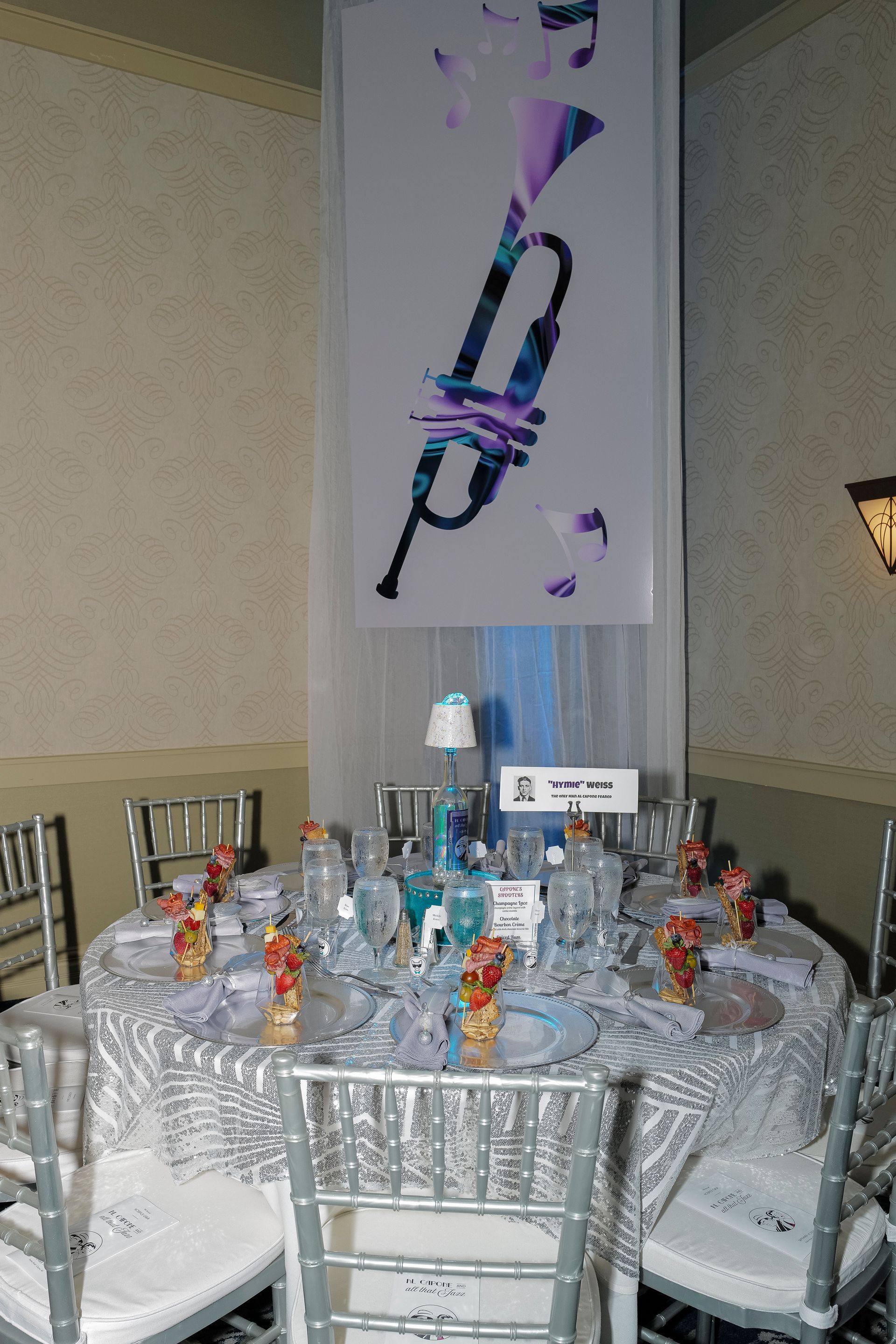 A table set for a party with a picture of a trumpet on the wall behind it.