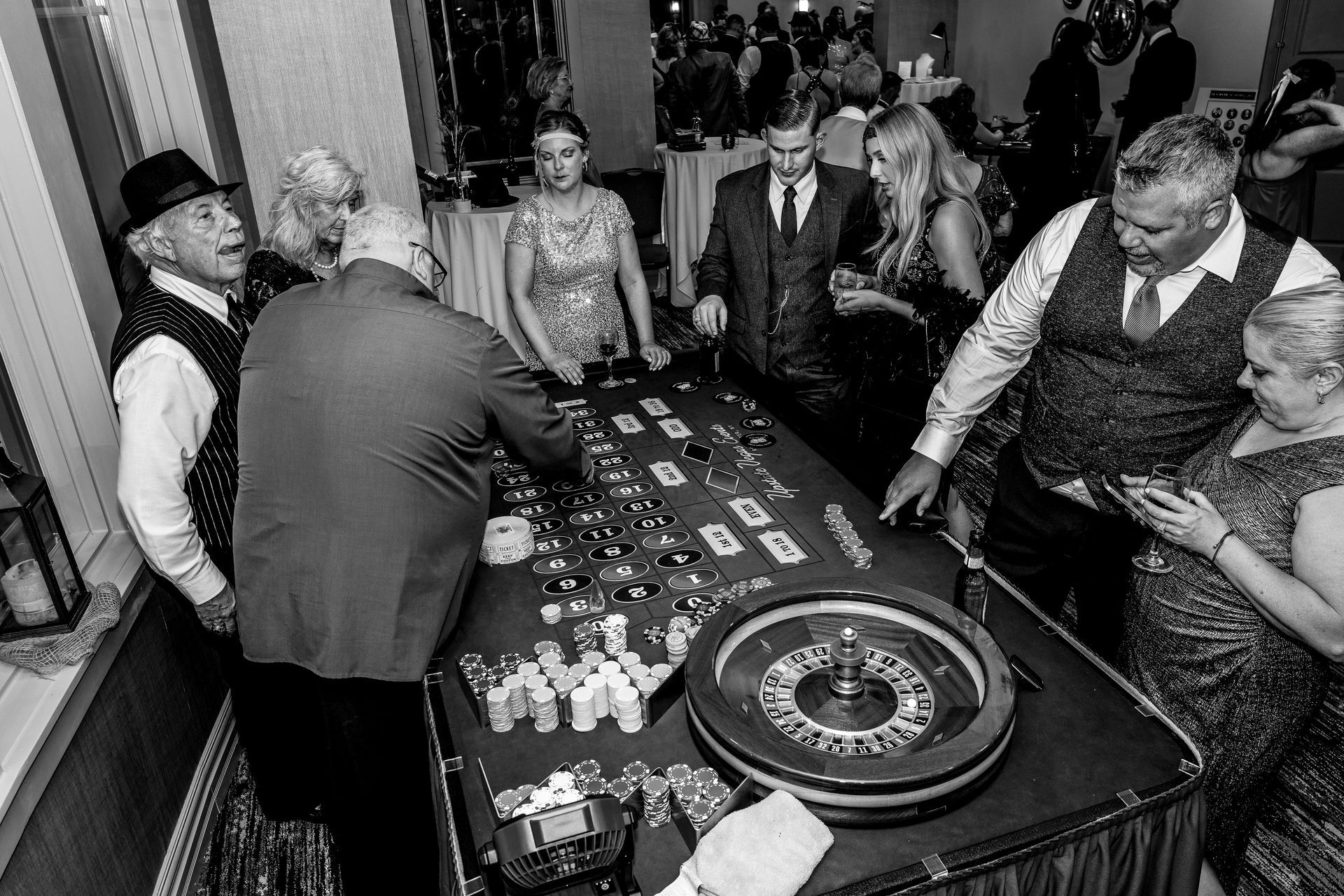 A group of people are playing roulette in a black and white photo.
