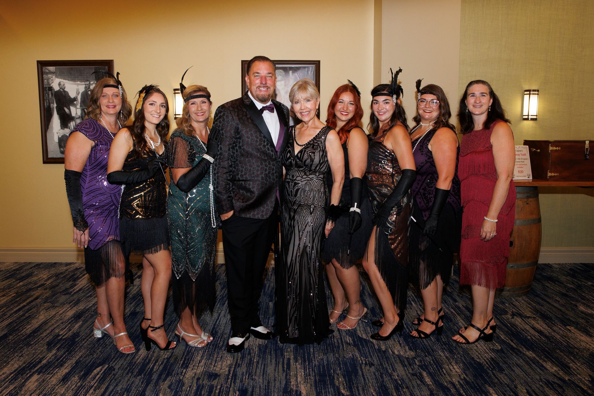 A group of people dressed in flapper costumes are posing for a picture.