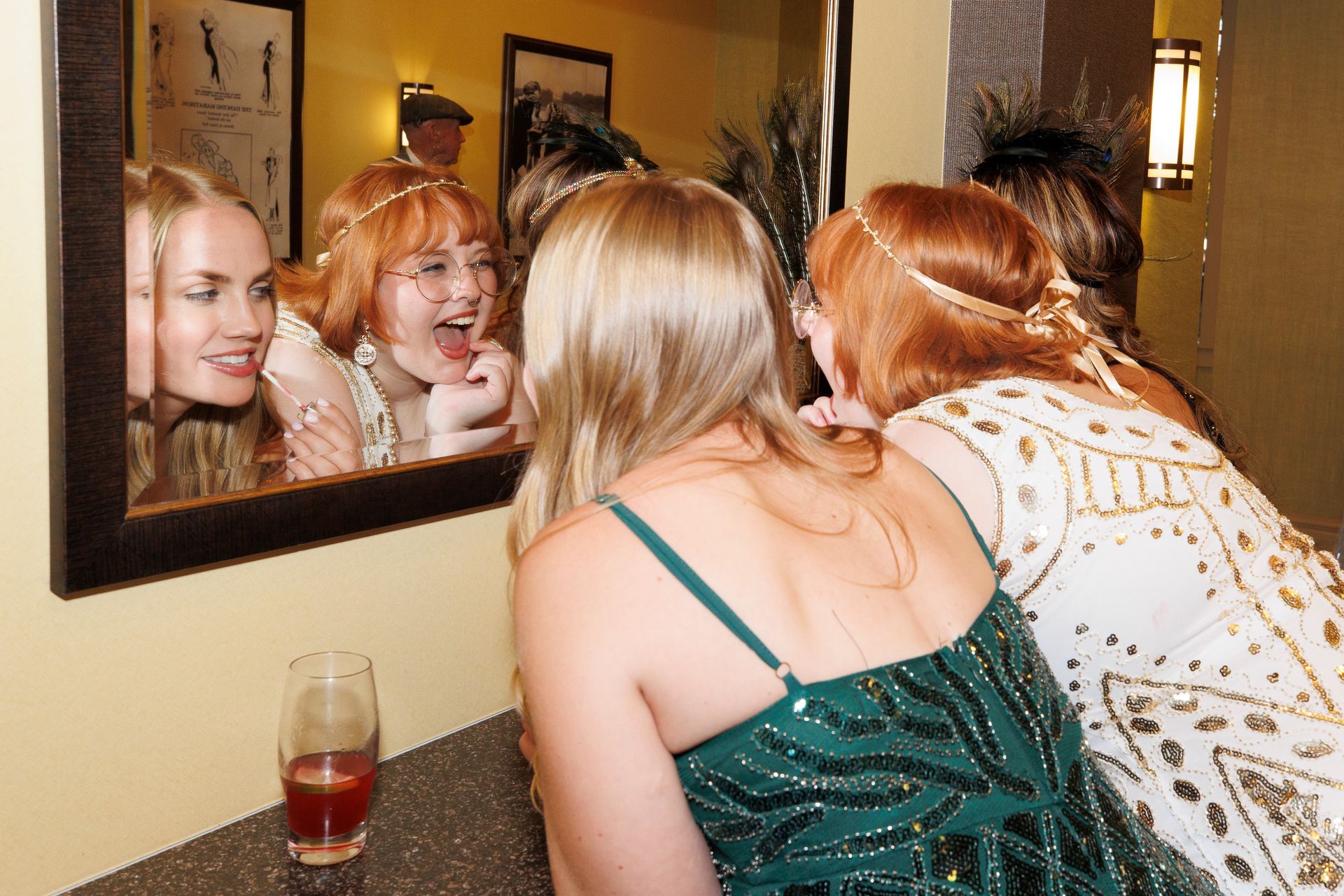 Two women are looking at their reflection in a mirror