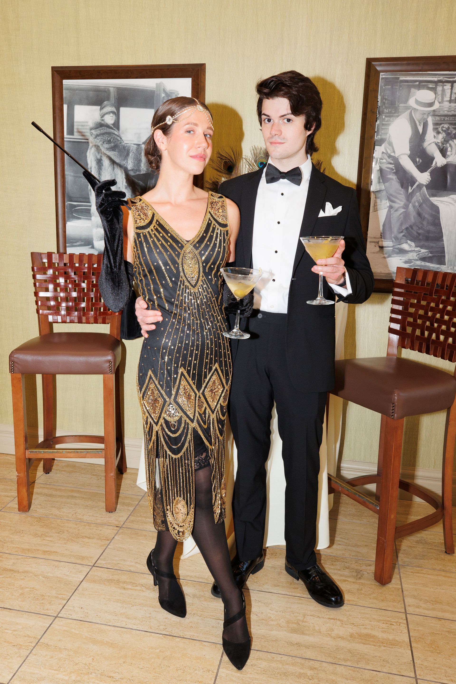 A man and a woman standing next to each other holding martini glasses