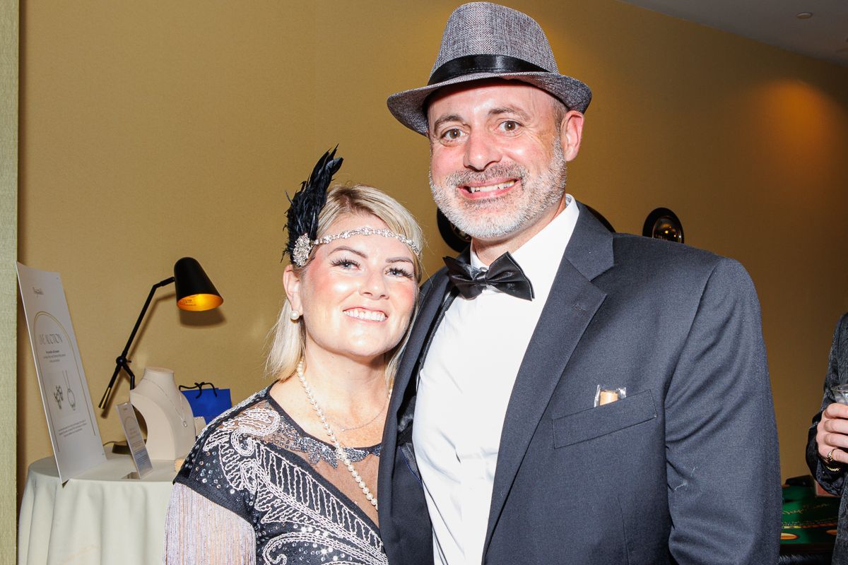 A man in a suit and a woman in a dress are posing for a picture.