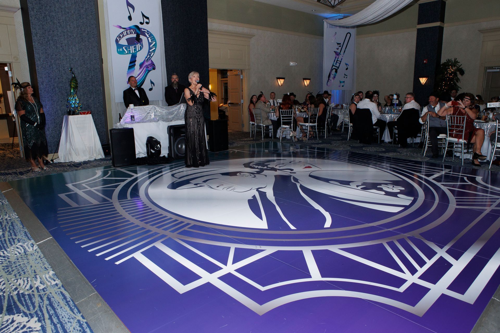A woman singing into a microphone on a purple dance floor