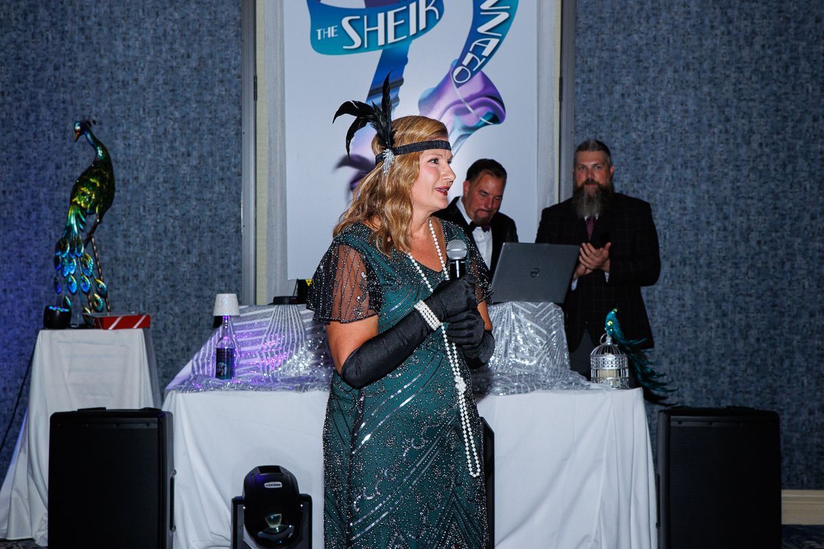 A woman in a green dress is standing in front of a microphone.