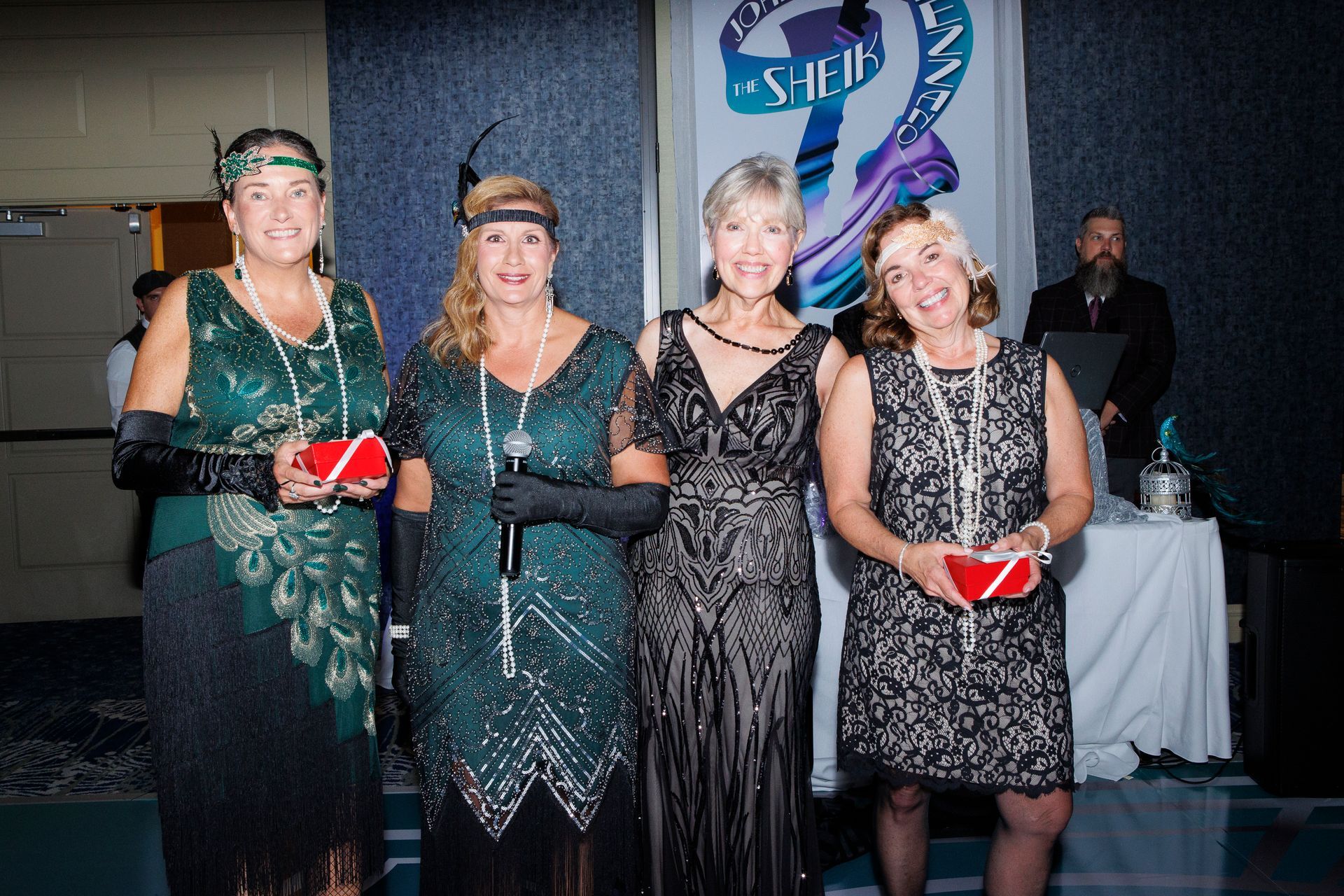 A group of women in flapper dresses are posing for a picture.