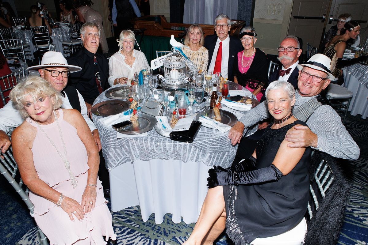 A group of people are sitting around a table at a party.