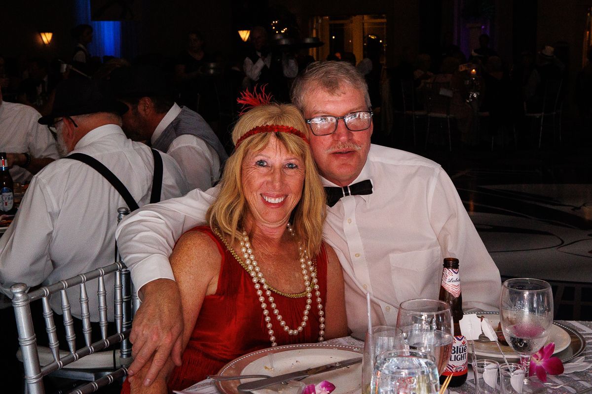 A man and a woman are posing for a picture at a table.
