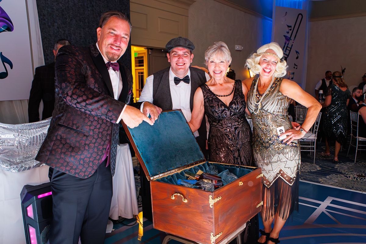 A group of people are standing around a trunk.