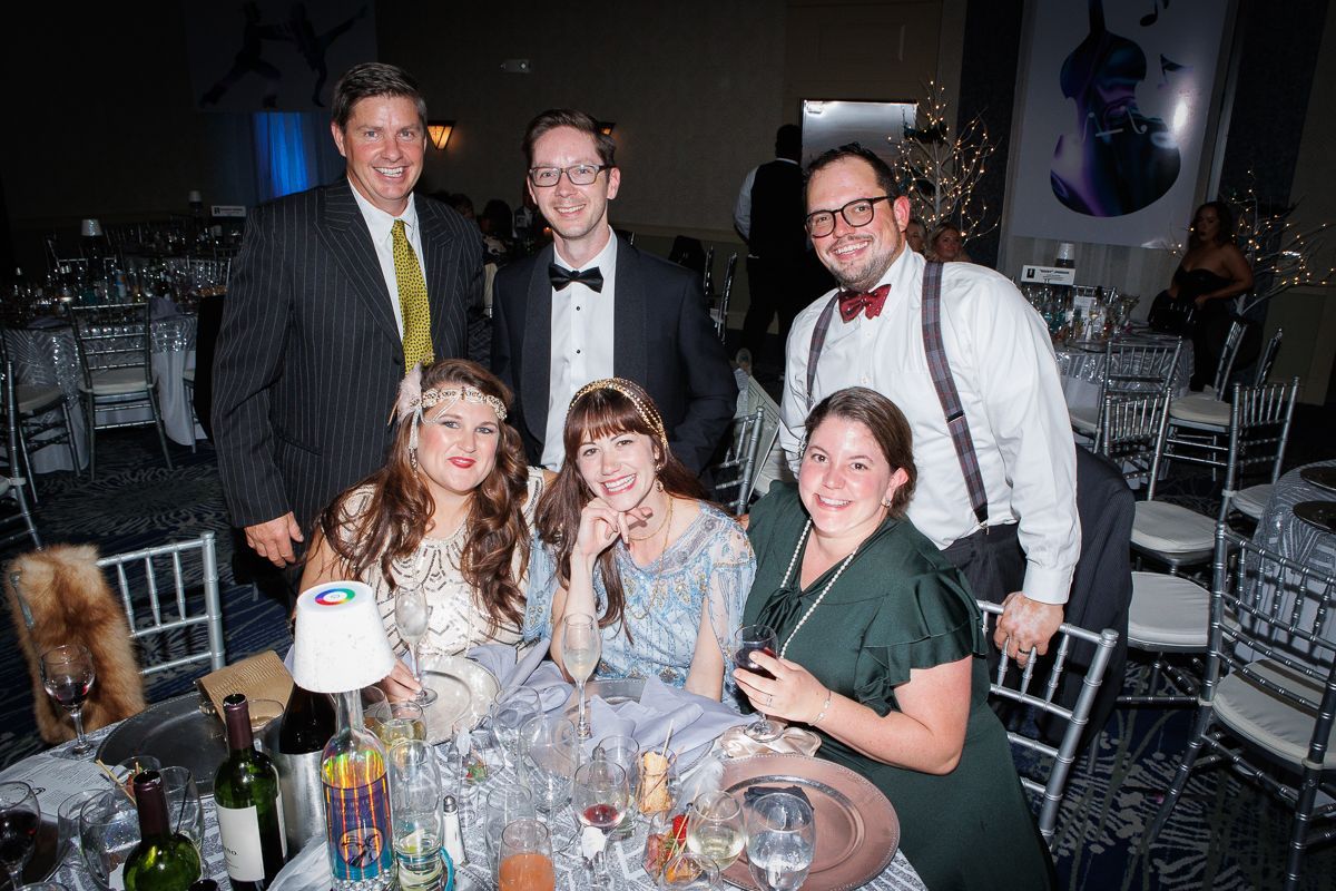 A group of people are posing for a picture at a table at a party.