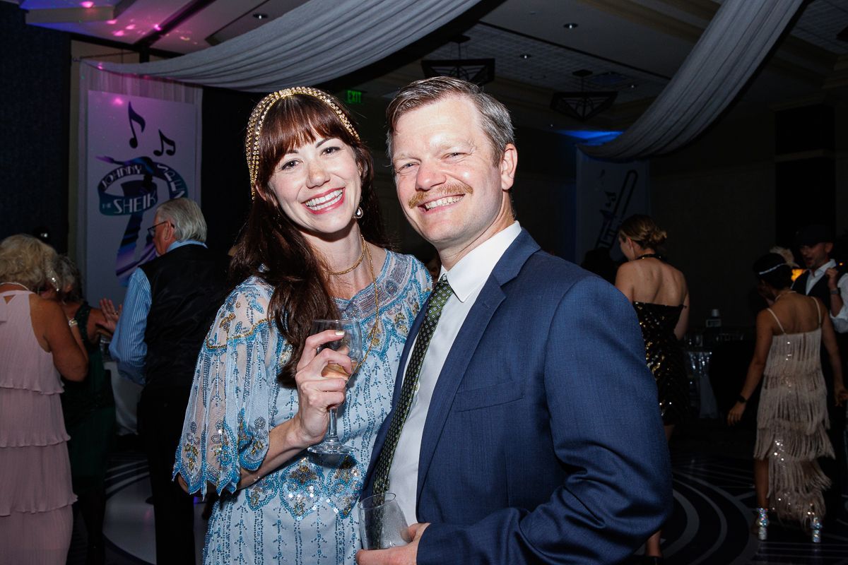 A man and a woman are posing for a picture at a party.