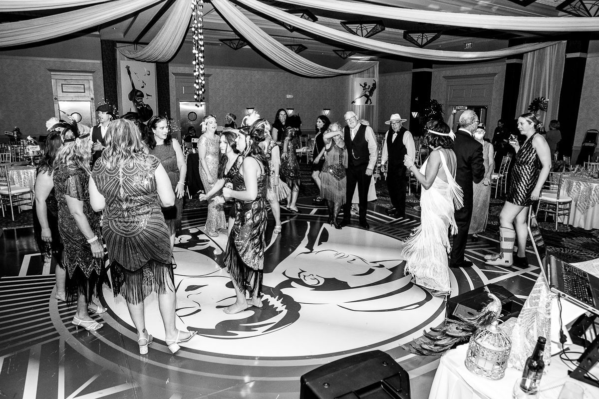 A black and white photo of a group of people dancing on a dance floor.