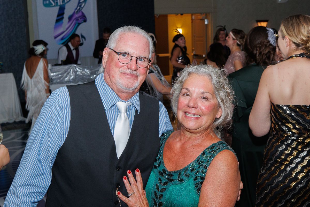 A man and woman are posing for a picture at a party