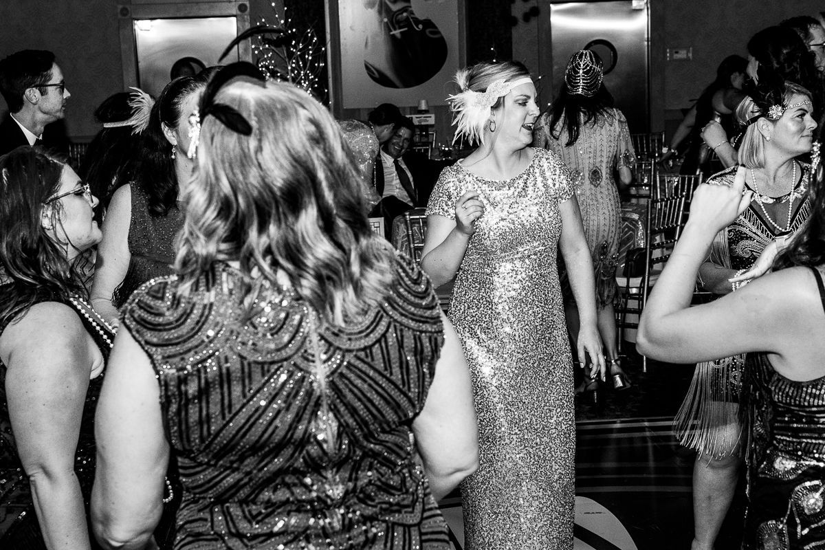 A black and white photo of a group of people dancing at a party.