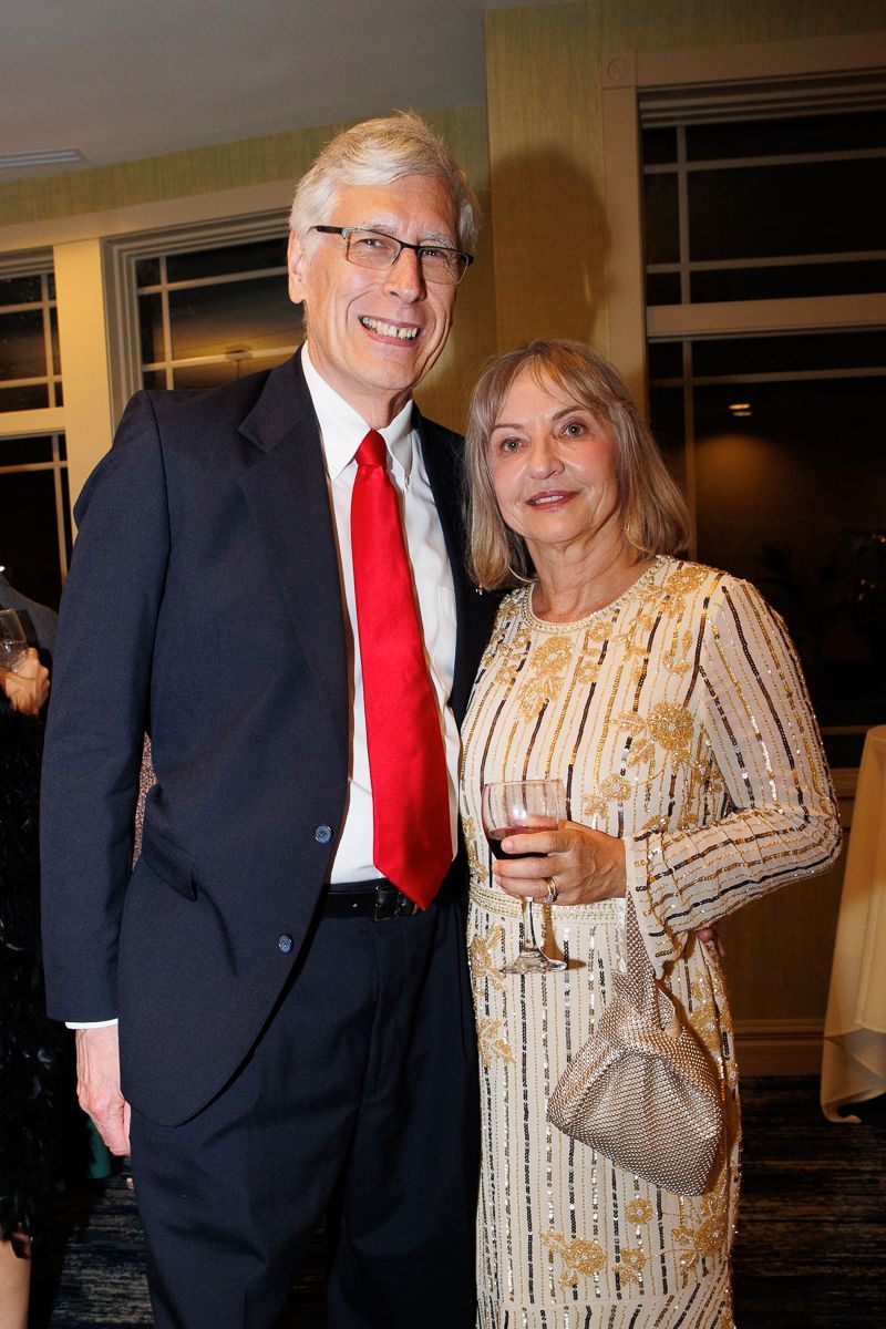 A man in a suit and tie is standing next to a woman in a dress.