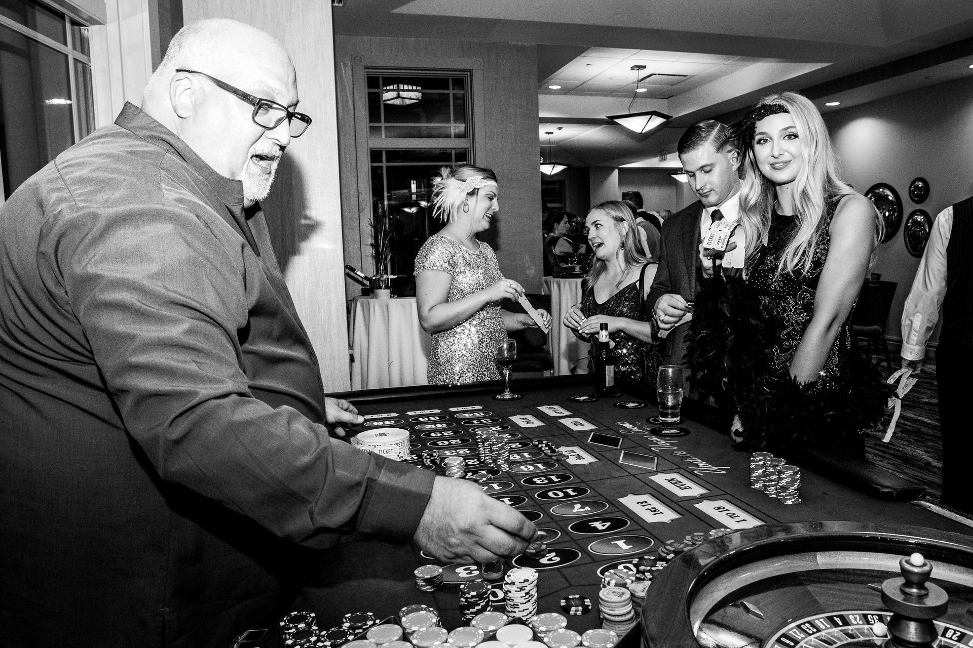 A group of people are playing roulette in a black and white photo.