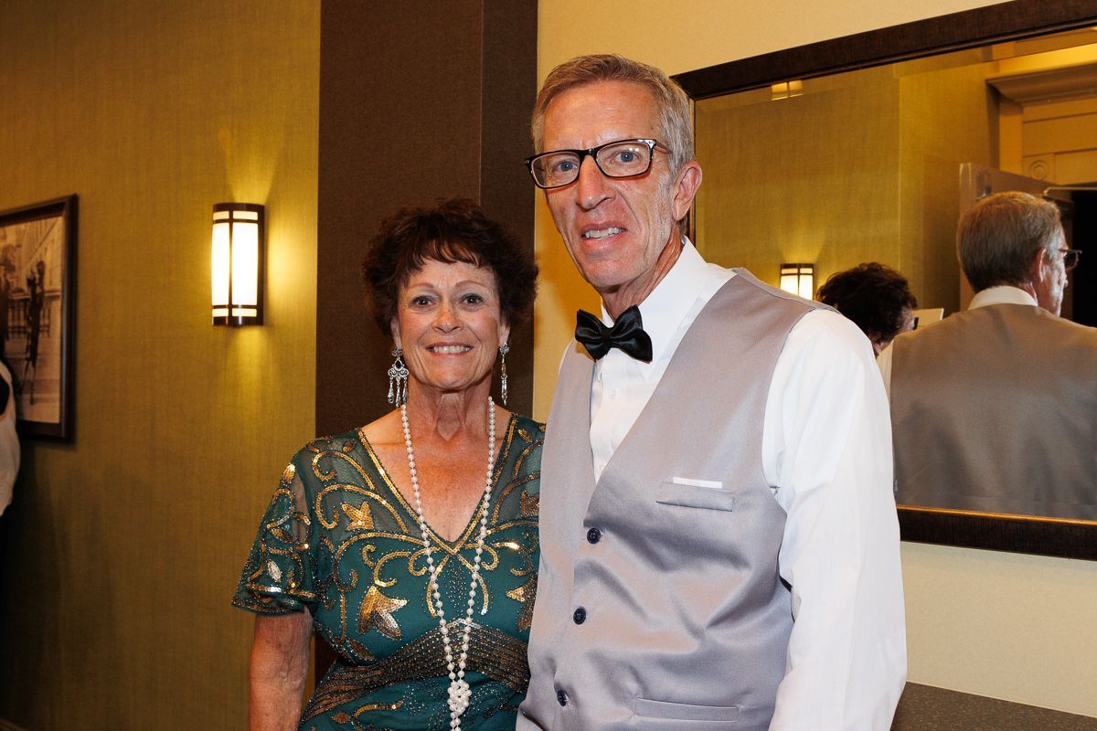 A man and a woman are posing for a picture in front of a mirror.