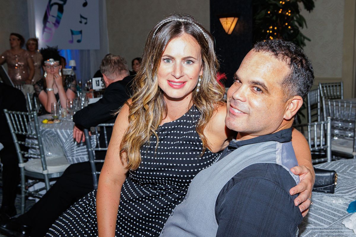A man and a woman are posing for a picture at a party.