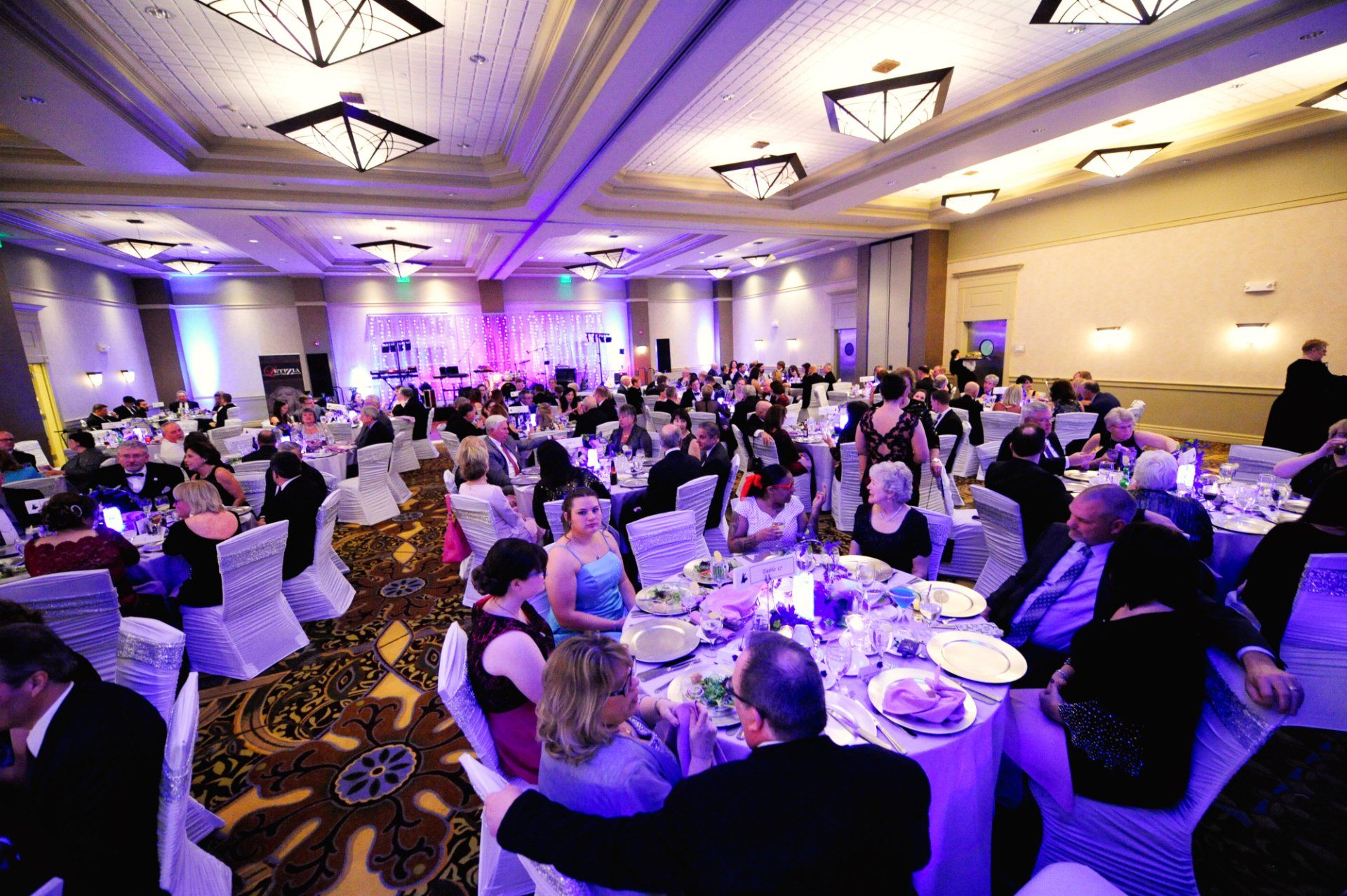 A large room filled with people sitting at tables
