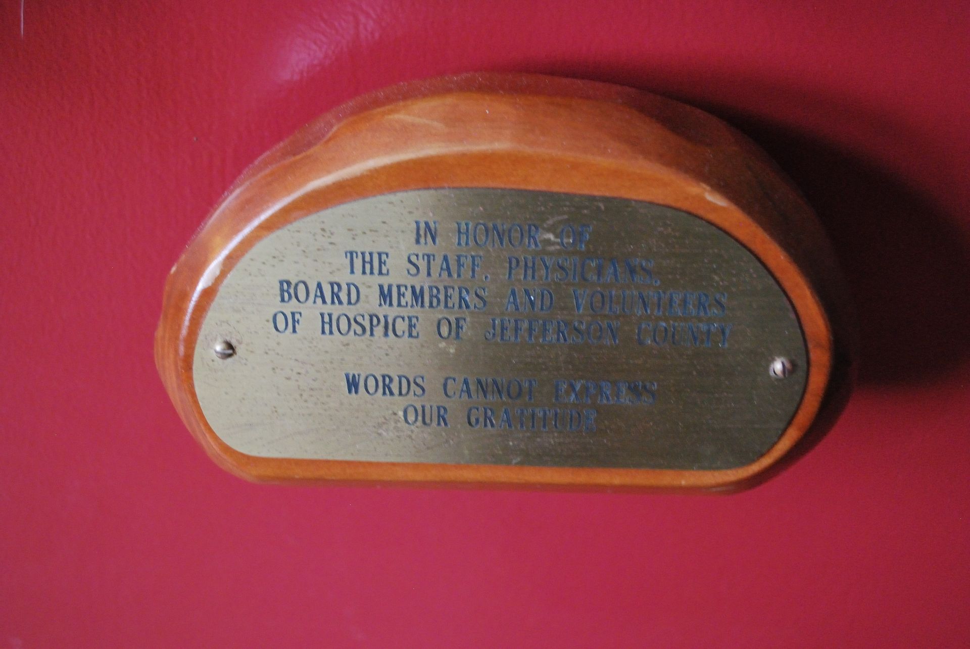 A wooden plaque that says in honor of the staff