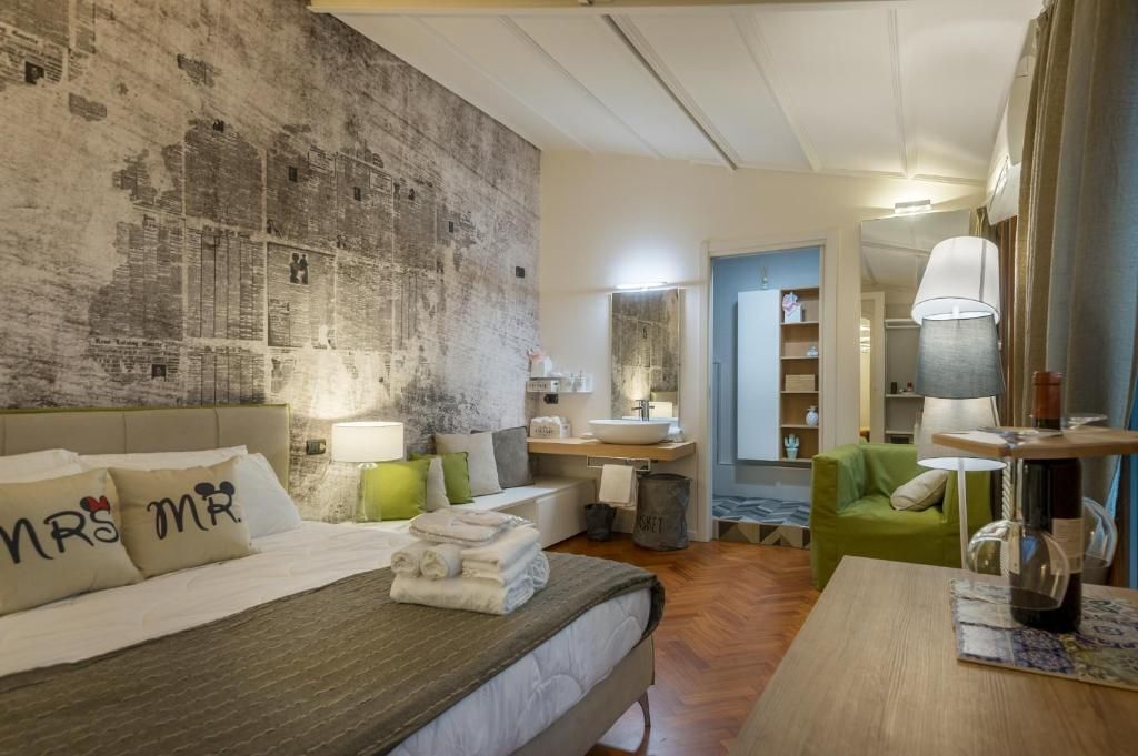 Una camera d'albergo con un letto king size e una sedia verde.