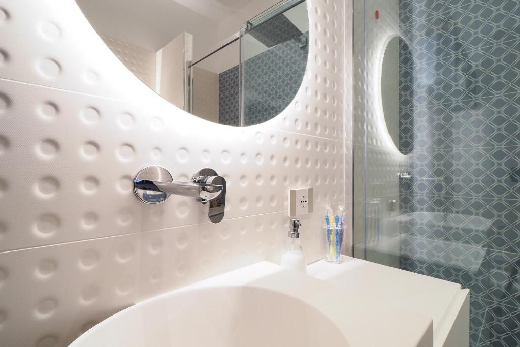 Un bagno con lavandino, specchio e doccia.