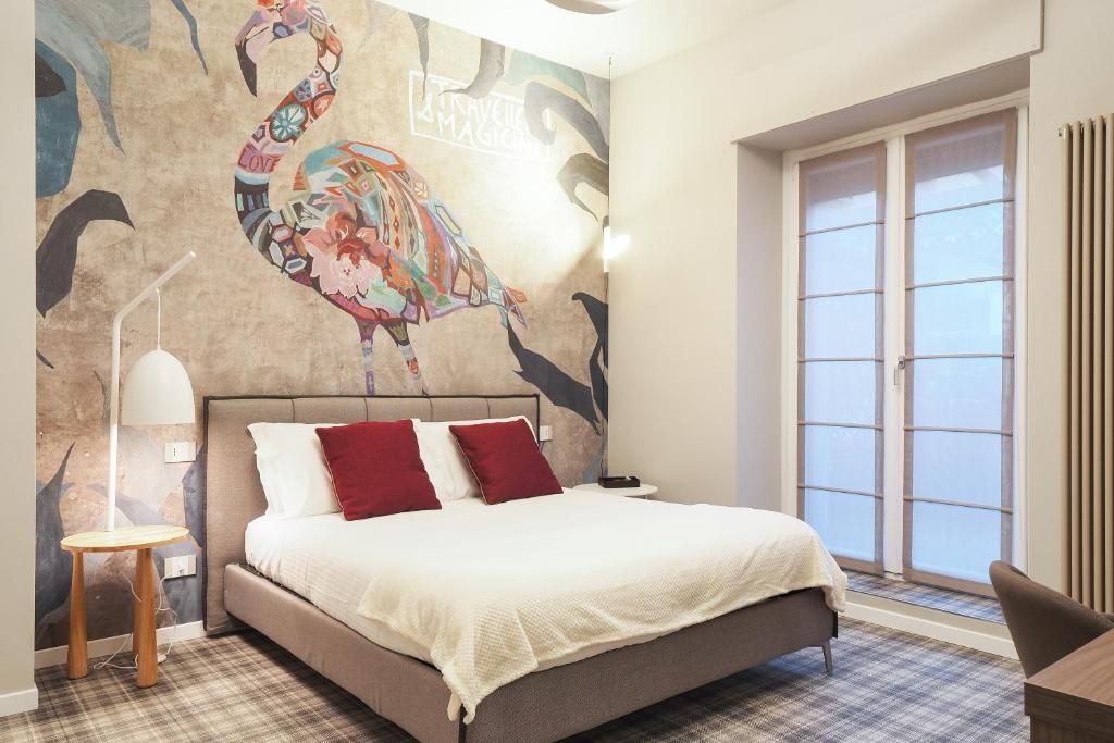 Una camera da letto con un letto grande e un fenicottero sul muro.