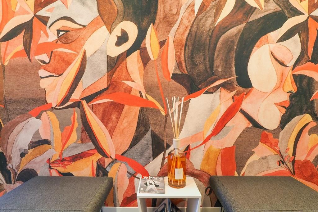 Una stanza con due pouf e un quadro sul muro.