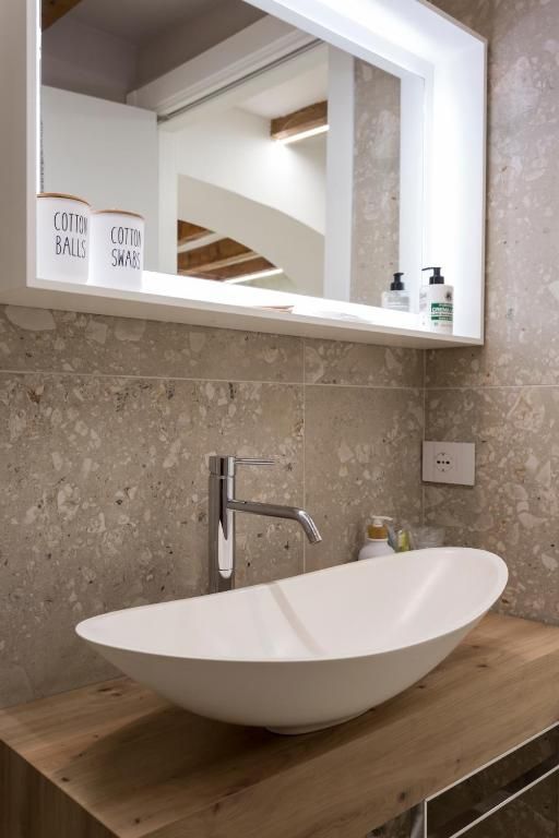 Un bagno con un lavandino e uno specchio sopra