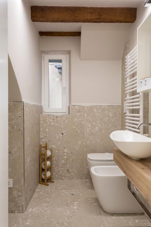 Un bagno con due water, un lavandino e una finestra.