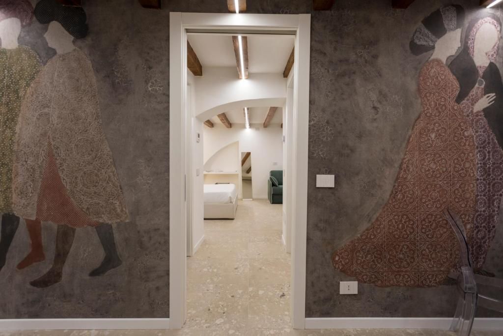 Una porta che conduce a una stanza con un dipinto sul muro.