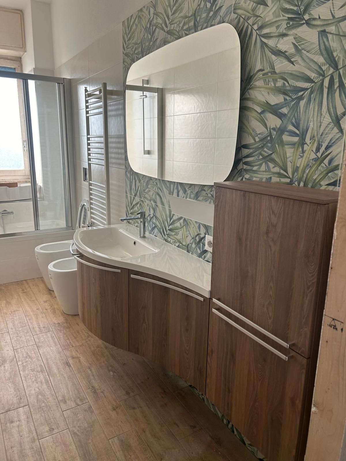 Un bagno con due lavandini, uno specchio e una vasca da bagno.