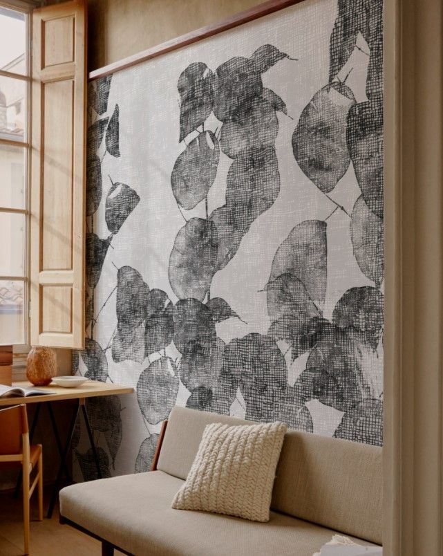 Un divano davanti a un muro con delle foglie sopra