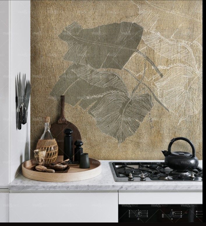 Una cucina con un dipinto di foglie sul muro