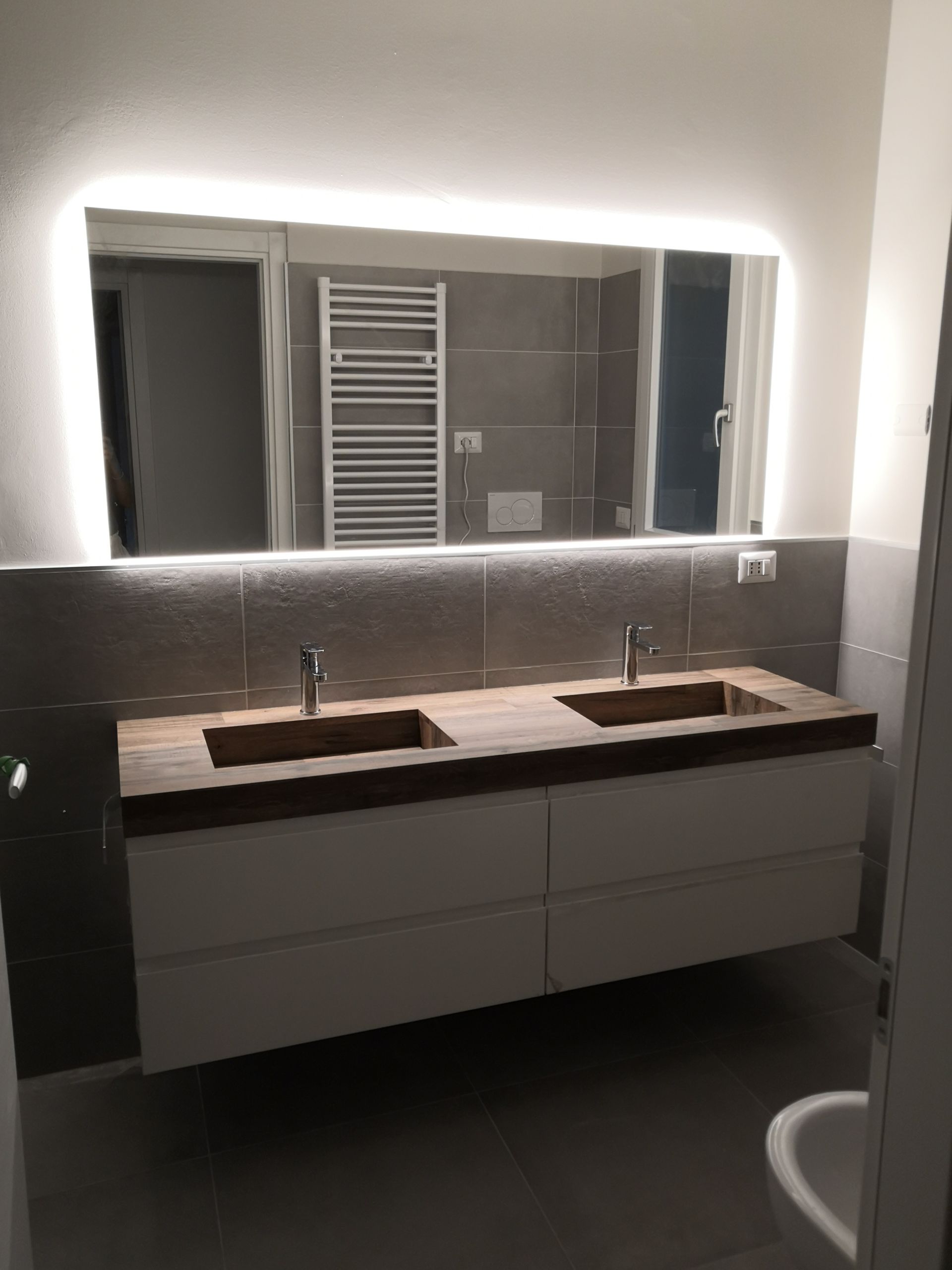 Un bagno con due lavandini e un grande specchio